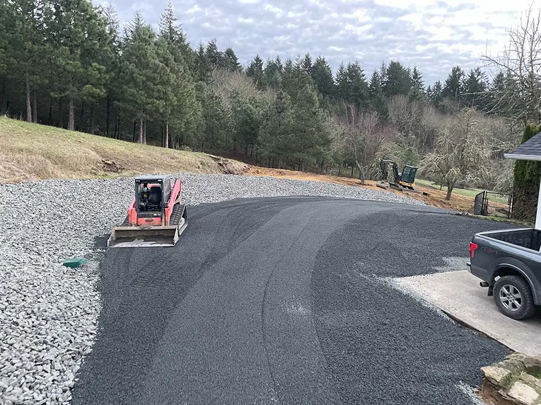 Finished gravel driveway and turnaround next to a house