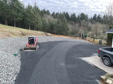 Finished gravel driveway and turnaround next to a house