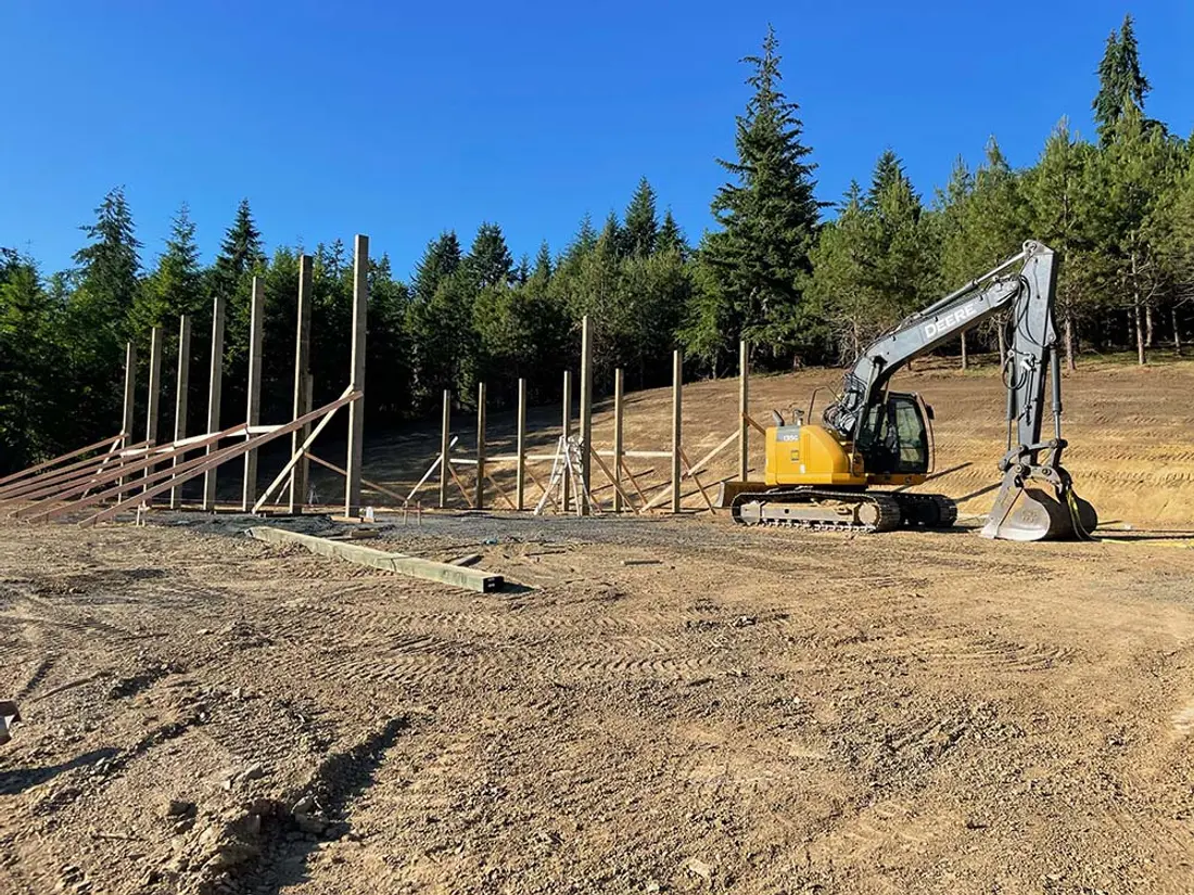 Pole-frame shop being built on a level pad cut into a hillside