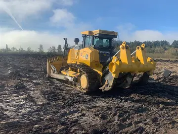 Dozer with ripper clearing ground for an outdoor horse arena